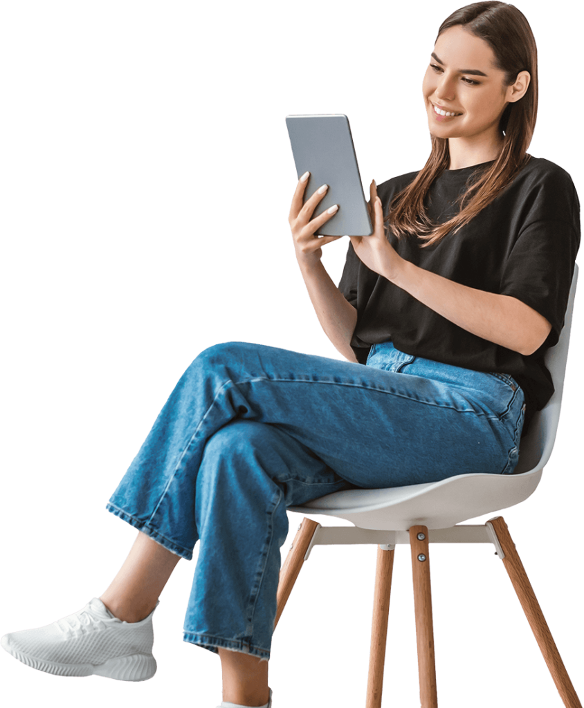 Woman sitting on a chair, smiling and using a tablet.